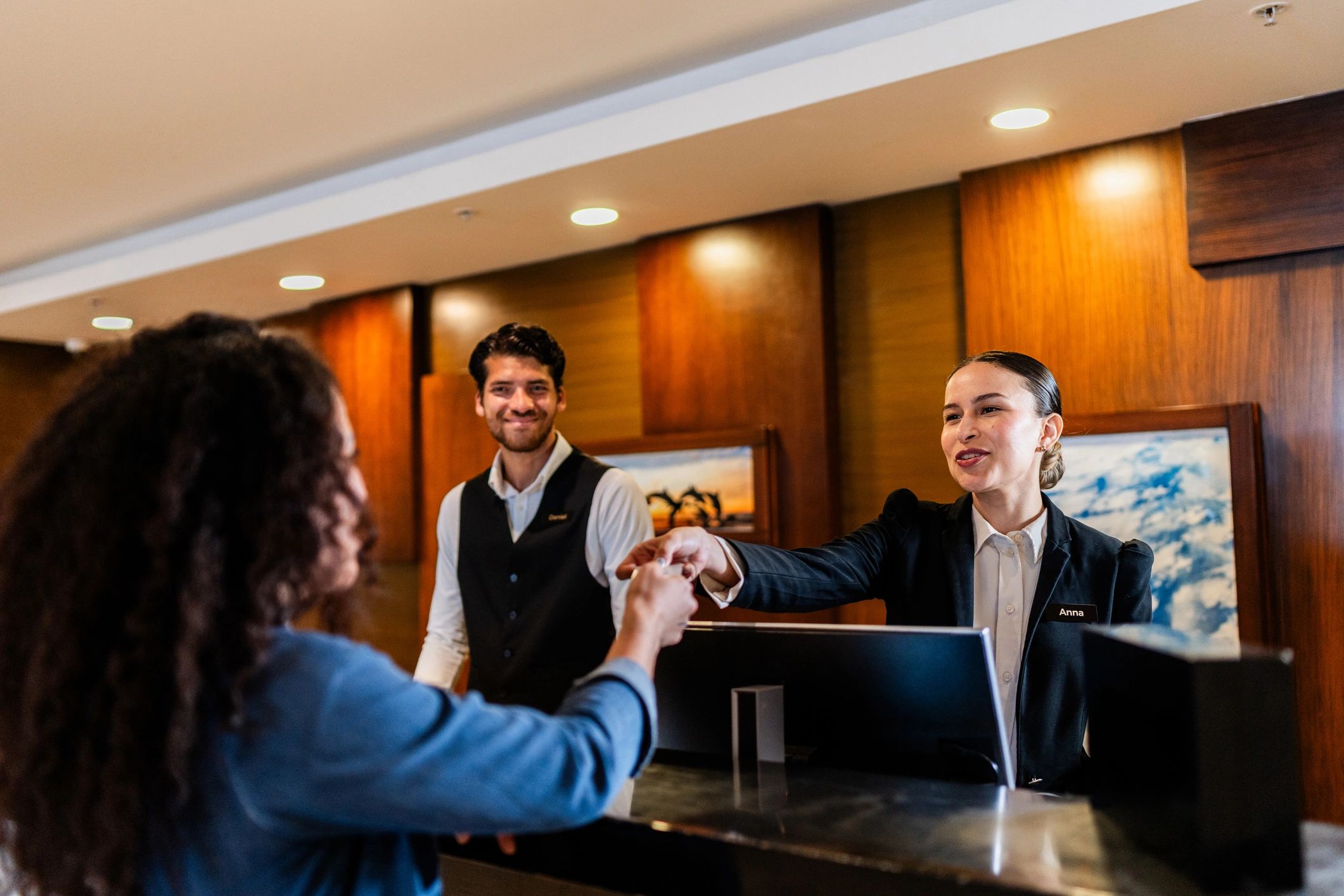 Receptionist handing a key card to a hotel guest